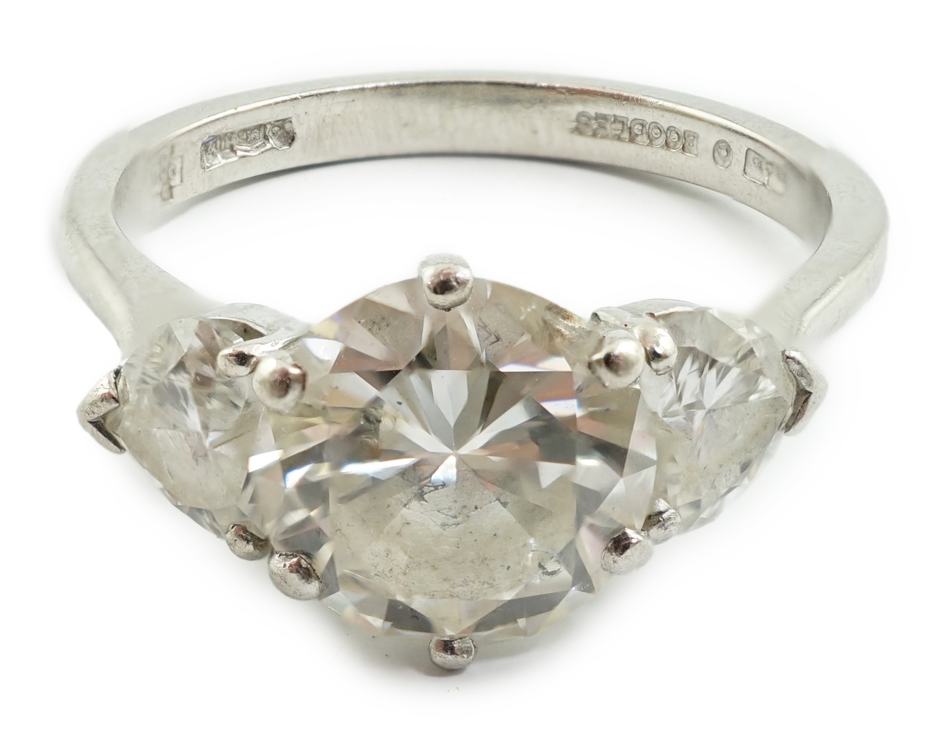 A modern Boodles & Dunthorne platinum and single stone diamond ring, with two stone heart shaped diamond set shoulders